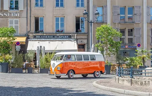 Photo du van en train de rouler sur une petite place