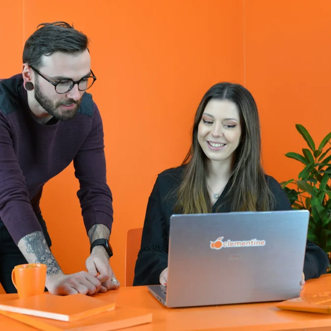 Photo d'un comptable en rendez-vous avec un client dans une salle entièrement orange