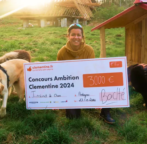 Grande gagnante du concours avec son chèque géant de 3000 € dans son jardin avec ses chiens